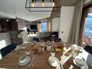 a wooden table with food on it in a living room at Penthouse luxe Tignes Lavachet 4 chambres pour 8 pers. avec terrasse - FR-1-641-72 in Tignes +7 photos