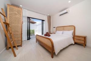 Un dormitorio con una cama y una ventana grande. en Brand New 4BR Balinese Style Pool Villa Kaia just 5 min drive from NaiHarn Beach, en Rawai Beach 24 fotos más