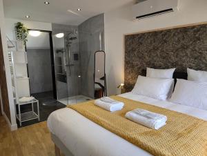 a bedroom with a large bed with two towels on it at La Suite - Villa Valmy - Hypercentre - Gare SNCF in Montluçon