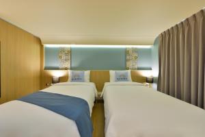 two beds sitting next to each other in a room at Kastel Bangkok Hotel in Bangkok +61 photos