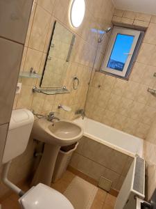 ein Badezimmer mit Waschbecken, Toilette und Badewanne in der Unterkunft LUCA apartament CENTRAL in Deva