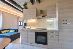 a kitchen with a stove top oven next to a couch at Le Rondini, comfy flat in Empoli