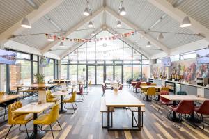 a restaurant with tables and chairs and windows at The Lodge Hotel in Newbury