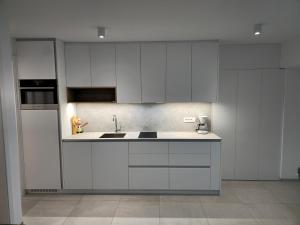 a kitchen with white cabinets and a sink at SeaView apartment Mirjam with Jacuzzi in Portorož