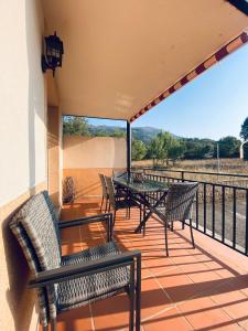 a patio with chairs and a table on a balcony at Guadarrama in Navaluenga