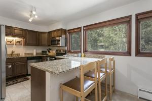 a kitchen with wooden cabinets and a granite counter top at G3 Meadow Creek townhouse in Vail