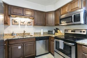 a kitchen with wooden cabinets and stainless steel appliances at G3 Meadow Creek townhouse in Vail