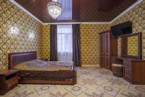 a bedroom with a bed and a dresser and a television at Hotel Diva in Krasnodar