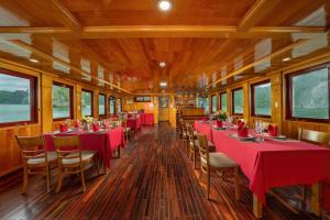 Un vagón comedor de un tren con mesas y sillas rojas. en Sunlight Boutique Cruise 69, en Cat Ba