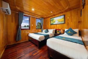 Habitación con 2 camas, paredes de madera y suelo de madera. en Sunlight Boutique Cruise 69, en Cat Ba