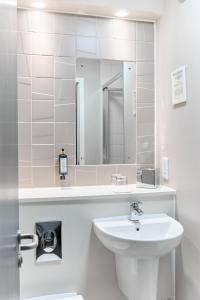 a white bathroom with a sink and a mirror at The Lodge Hotel in Newbury