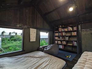 a small room with a bed and a book shelf at Ivy Coffee Farm - Cabin House in Ðưc Trọng