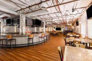 a bar in a restaurant with tables and chairs at Ramada by Wyndham Kingman in Kingman