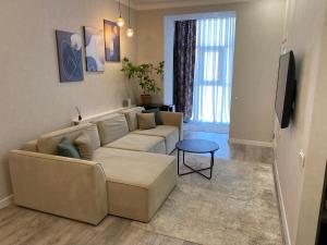 a living room with a couch and a tv at Юго Восток Идеально для командированного и туриста in Karagandy