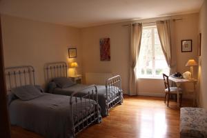 1 dormitorio con 2 camas, escritorio y ventana en Les Jardins de L'Aulnaie - FERME DEFINITIVEMENT, en Fontaine-sous-Jouy