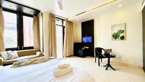 a bedroom with a bed and a desk with a laptop at BluO Studio - M Block Mkt Greater Kailash in New Delhi