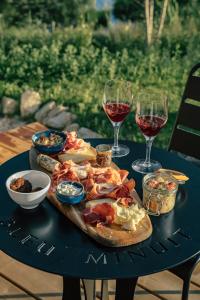 a table with a plate of food and two glasses of wine at Bleu Minuit La Rive Etoilée in Thézillieu
