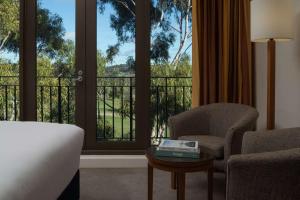 a hotel room with a bed and a chair and a window at Yarra Valley Lodge in Wonga Park