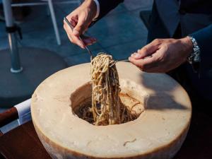 a person is eating noodles from a bowl at The 1932 Hotel & Spa Cap d'Antibes - MGallery Collection in Juan-les-Pins