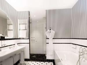 a bathroom with a tub and two sinks and a bath tub at The 1932 Hotel & Spa Cap d'Antibes - MGallery Collection in Juan-les-Pins