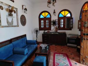 a living room with a blue couch and a kitchen at Villa Andalusia Dahab blue in Dahab