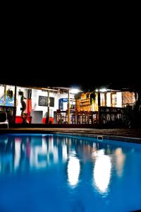a swimming pool in front of a gas station at night at Tri M Waves Lodge in Ponta do Ouro