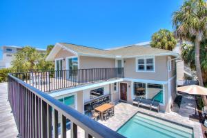 a house with a balcony with a swimming pool at Forever Sunshine - Beach Vacation Rental in Clearwater Beach
