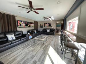 a living room with leather furniture and a ceiling fan at Forever Sunshine - Beach Vacation Rental in Clearwater Beach