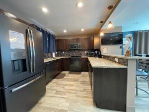 a kitchen with stainless steel appliances and wooden cabinets at Forever Sunshine - Beach Vacation Rental in Clearwater Beach