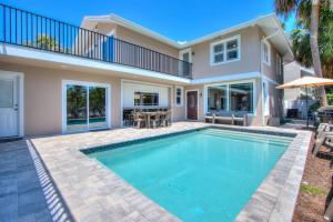 a swimming pool in front of a house at Forever Sunshine - Beach Vacation Rental in Clearwater Beach