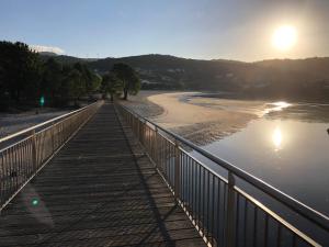 a bridge over a river with the sun in the sky at Pensión Casa de Casiano en Esteiro in Muros