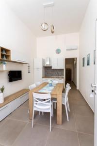 a kitchen and dining room with a wooden table and chairs at casa vacanze Diletta in Santa Maria al Bagno