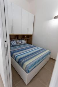 a small bedroom with a bed with white cabinets at casa vacanze Diletta in Santa Maria al Bagno +2 photos