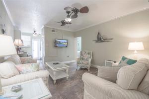 a living room with white furniture and a ceiling fan at Clearwater Beach Suites #105 in Clearwater Beach
