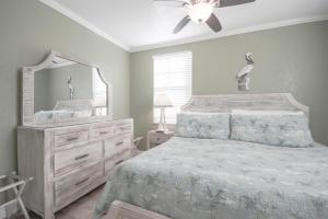 a bedroom with a bed with a dresser and a mirror at Clearwater Beach Suites #105 in Clearwater Beach +22 photos