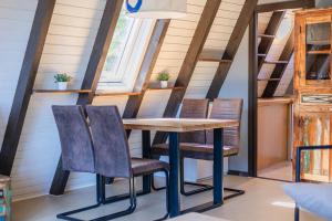 a table and chairs in a tiny house at Ferienwohnpark Immenstaad am Bodensee Nurdachhaus Typ 7 ND 39 in Immenstaad am Bodensee +10 photos