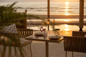 a table with two chairs and a table with a view of the ocean at Sibaya Beach Resort, Morjim in Morjim +50 photos