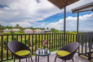 a patio with two chairs and a table on a balcony at Sibaya Beach Resort, Morjim in Morjim