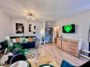 a living room with a blue couch and a green heart on the wall at New Stylish Apartment City Center Self Check-In in Narva