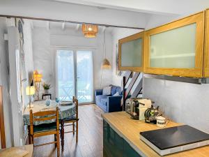 a kitchen with a table and a living room at Calme Jardin & Parking prox Royan Appart 2 in Médis