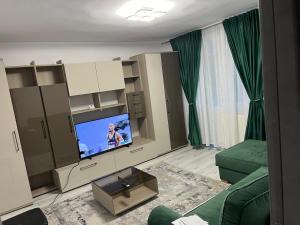 ein Wohnzimmer mit einer grünen Couch und einem Fernseher in der Unterkunft LUCA apartament CENTRAL in Deva