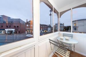 a balcony with a table and a view of a street at Comfy Flat in Staines in Staines upon Thames