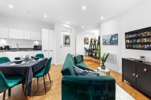 a living room with a table and green chairs at Comfy Flat in Staines in Staines upon Thames