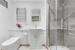 a white bathroom with a toilet sink and a shower at Comfy Flat in Staines in Staines upon Thames +15 photos