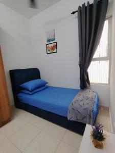 a small bedroom with a blue bed and a window at Aurora's Place at Alanis Residence in Sepang +9 photos