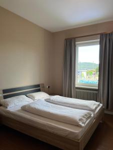 a bed in a bedroom with a large window at Hotel Restaurant Shanghai Garten in Klettgau