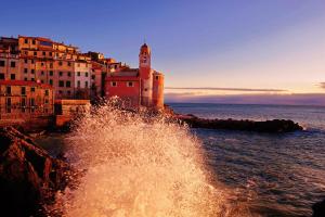a wave in the water in front of a city at Gambero Nero in Tellaro
