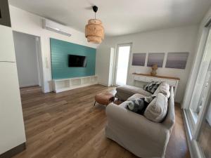 a living room with a couch and a tv at Fövi Inn in Balatonudvari