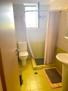 a bathroom with a toilet and a shower and a sink at Wave Sound - summer apartment in Kakóvatos