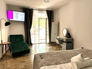 a bedroom with a green bed and a sliding glass door at Complex Omnia - Apartamente Husi in Huşi